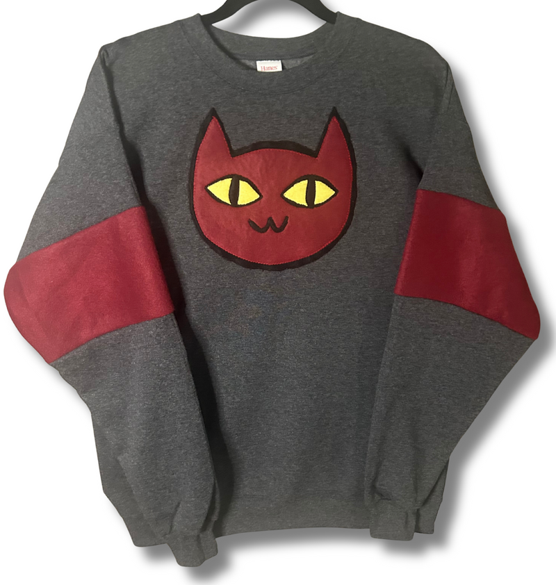 Gray sweatshirt with red sleeves and a red cat face design on a white background